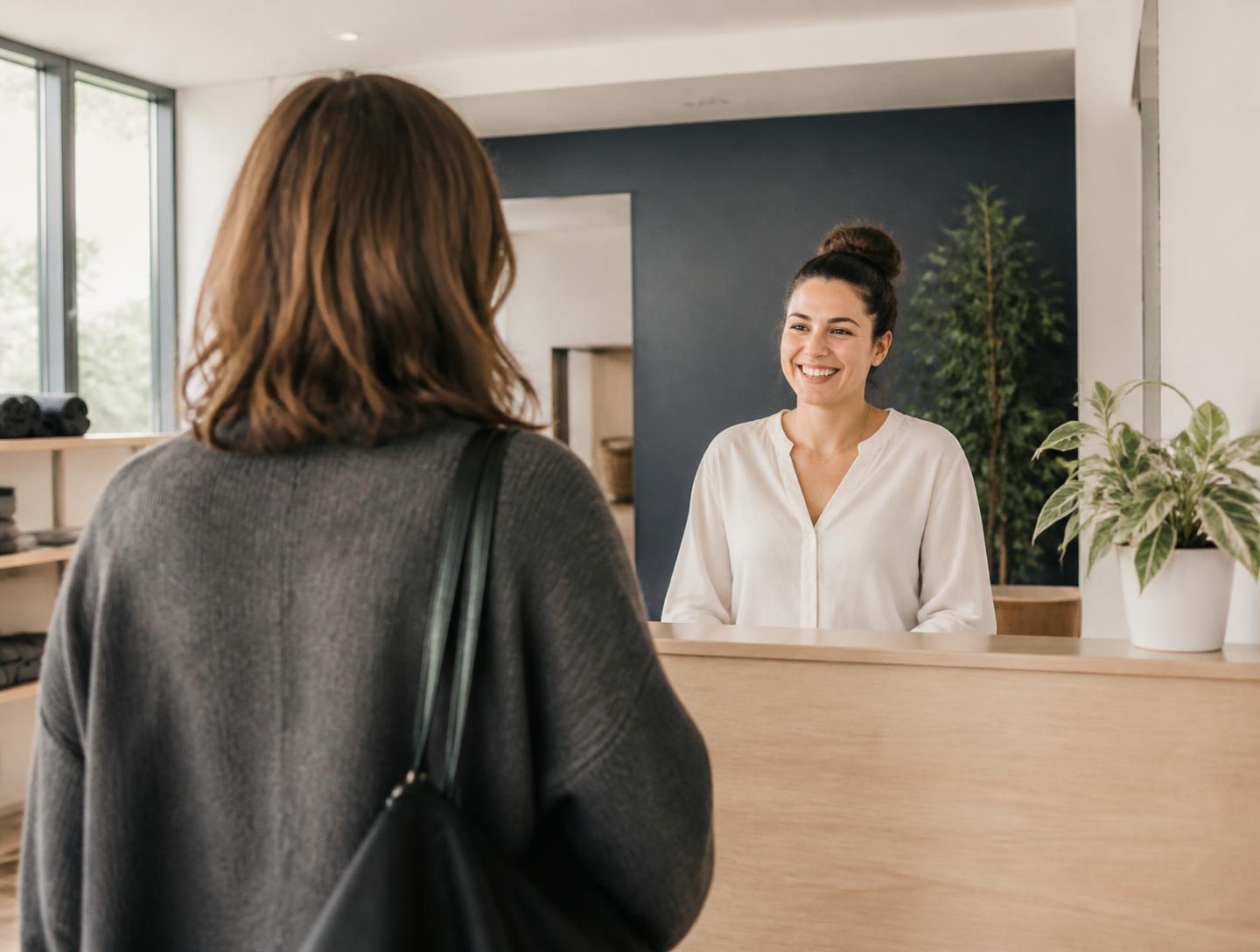 Member being welcomed into a Restore studio by the front-desk team